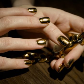 woman-is-holding-gold-instrument-with-gold-glitter-it